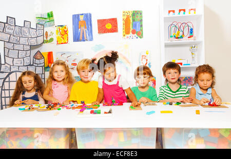 Big group of diverse looking preschool boys and girls play with modeling clay in class in kindergarten Stock Photo