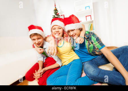Teens kids on Christmas party in Santa hats Stock Photo