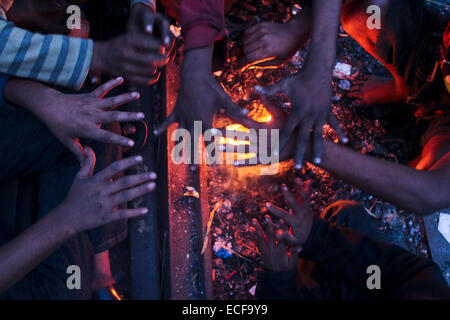 Dhaka, Bangladesh. 13th December, 2014. Homeless children create fire by using discarded wood or plastic to provide some warmth as winter temperatures drop in Dhaka. Credit:  zakir hossain chowdhury zakir/Alamy Live News Stock Photo
