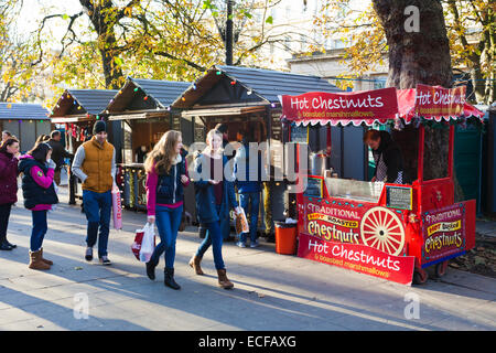 Shoppers enjoying the winter sunshine at the Christmas market in the Promenade, Cheltenham, Gloucestershire UK Stock Photo