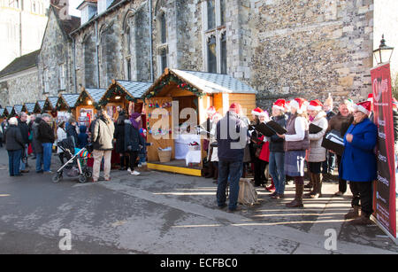 Carol singers performing in The Close Winchester Cathedral Hampshire UK . Singing Christmas carols Stock Photo