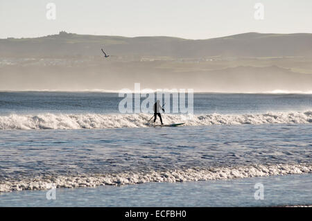 Bridlington, East Yorkshire, UK. 13th December, 2014. Man surfing in North Sea, nice weather on Saturday the 13 th December at Hunmanby Gap East Yorkshire near Bridlington Credit:  picturesbyrob/Alamy Live News Stock Photo