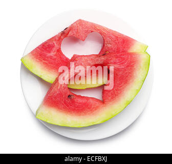 Slices of watermelon with cut out heart shape in plate on white background Stock Photo