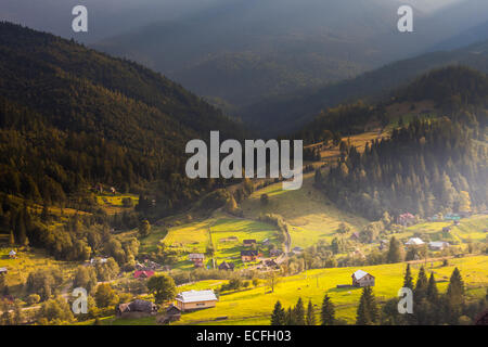 Beautiful light beam in morning with village on mountain valleys Stock Photo