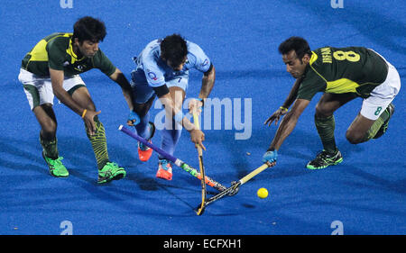 Bhubaneswar. 13th Dec, 2014. India's Manpreet Singh (C) vies for the ball between Pakistan's Zohaib Ashraf (L) and Muhammad Tousiq during the semifinal match against India at Hero Hockey Champions Trophy 2014 match at Kalinga Stadium in Bhubaneswar on December 13, 2014. Pakistan won 4-3. © Zheng Huansong/Xinhua/Alamy Live News Stock Photo