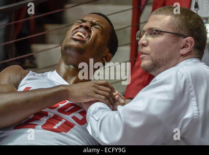 Albuquerque, New Mexico, USA. 13th Dec, 2014. Roberto E. Rosales.Lobo Sam Logwood (Cq)left, is looked at by trainer Nate Burley(Cq) after leaving the game with a shoulder injury. Lobos defeated ULM 54 TO 46. © Roberto E. Rosales/Albuquerque Journal/ZUMA Wire/Alamy Live News Stock Photo