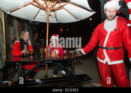 London, UK. 13th December, 2014. In a tradition dating back to 2004, having completed their Christmas preparations lots of Santas came out in London. They were raising money for the St Christopher's Hospice in South London and having a few drinks before their busiest day of the year. Credit:  Neil Cordell/Alamy Live News Stock Photo