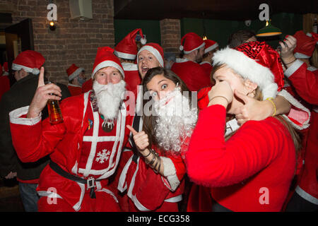 London, UK. 13th December, 2014. In a tradition dating back to 2004, having completed their Christmas preparations lots of Santas came out in London. They were raising money for the St Christopher's Hospice in South London and having a few drinks before their busiest day of the year. Credit:  Neil Cordell/Alamy Live News Stock Photo