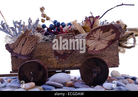 Miniature cart filled with flowers on a rock path Stock Photo