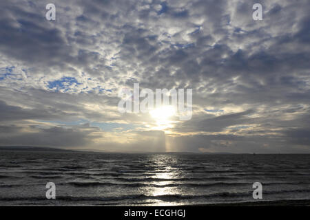 Solent, Hampshire, UK. 14th Dec, 2014. Lepe on the Solent, Hampshire, UK. The afternoon sun breaks through the clouds over the Isle of Wight, above the stormy waters of the Solent churned up by the strong winds blowing along the south coast of England today. Credit:  Julia Gavin UK/Alamy Live News Stock Photo