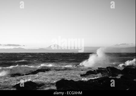 Waves break over the Miura Peninsula, Japan with Mount Fuji in the background Stock Photo