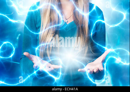 blond teenager girl with open hands, surrounded by lights and energy Stock Photo