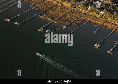 Aerial view of a boat passing through a channel past boat docks in Mt Pleasant, SC Stock Photo