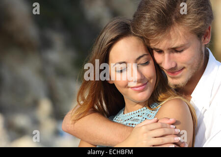 Couple in love hugging and feeling the romance with closed eyes outdoors Stock Photo
