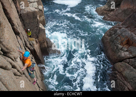 Iain Millar - a professional mountain guide - rock climbing up a sea stack near Gweedore, County Donegal, Ireland. Stock Photo