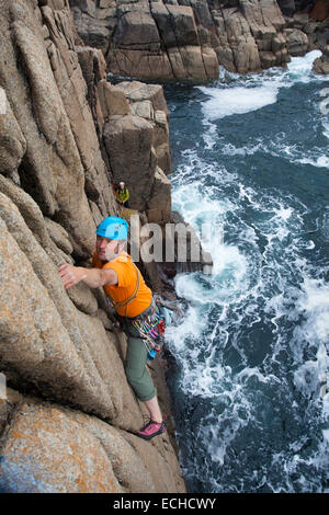 Iain Millar - a professional mountain guide - rock climbing up a sea stack near Gweedore, County Donegal, Ireland. Stock Photo