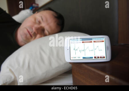 Man sleeping while having his ECG monitored using a Custo Kybe heart monitor. Stock Photo