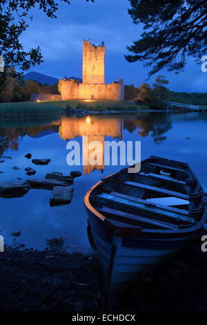 Fishing boat and Ross Castle illuminated at dusk, Lough Leane, Killarney National Park, County Kerry, Ireland. Stock Photo