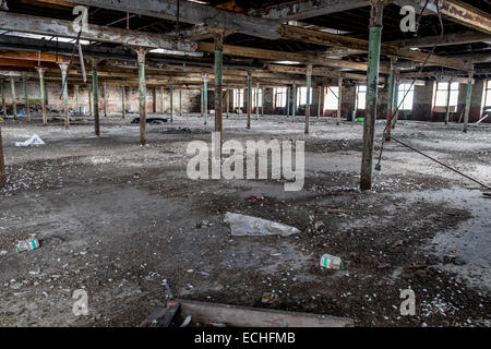 The main room in a disused  factory where Cotton was produced, many roof metal roof supports, with lots of debris on the ground Stock Photo