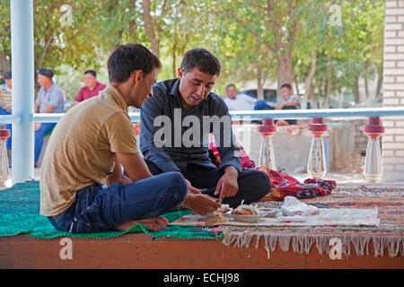 Two Turkmen having lunch in a traditional Arabic restaurant by sitting on the table, Turkmenistan Stock Photo