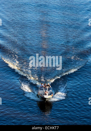 Teens driving an isolated motorboat / skiff , Finland Stock Photo