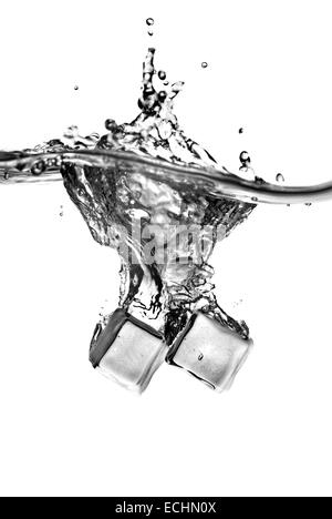 ice cubes dropped into water with splash isolated on white Stock Photo