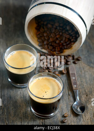Hot espresso cups with coffee beans on wooden background Stock Photo