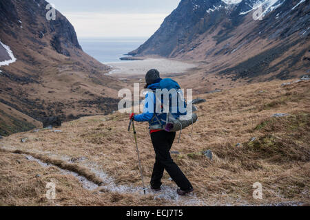 Female hiker hiking trail towards Horseid beach, Moskenesøy, Lofoten Islands, Norway Stock Photo