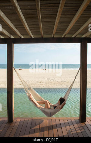 Woman laying on a hamock at a small hotel in the coast of Oaxaca, Mexico. Stock Photo