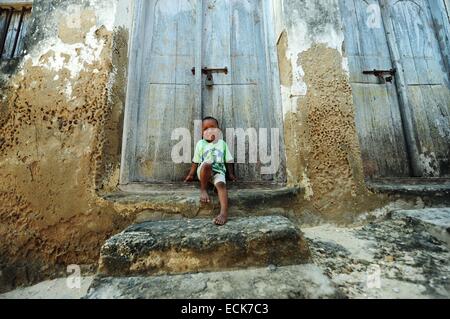Kenya, Lamu archipelago, Lamu, little boy in front of large colonial door Stock Photo