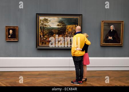 Germany, Berlin, Kulturforum, GemΣldegalerie (Picture Gallery), couple admiring a painting Christ on the Road to Calvary (1606) by Pieter Brueghel the Younger Stock Photo