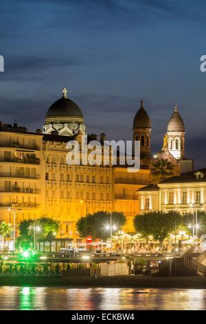 France, Var, Saint Raphael, beach of Veillat, night seasonal worker on the promenade des Bains, in the background the Basilica Notre Dame de la Victoire Stock Photo