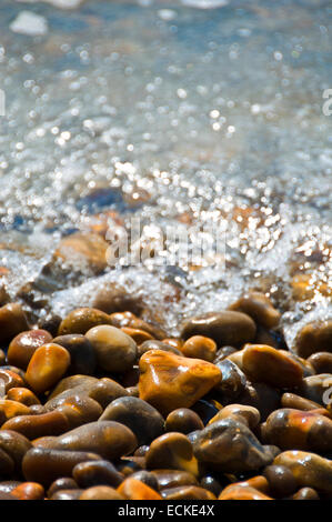 Vertical view of small colourful pebbles and the sea in the Isle of Wight. Stock Photo