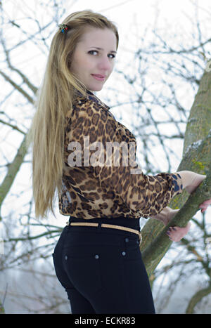 girl holds on a tree branch Stock Photo