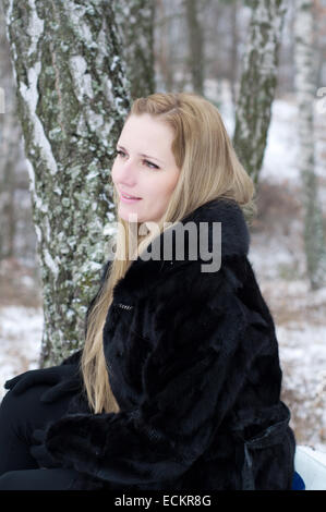 Girl in winter around the stump Stock Photo