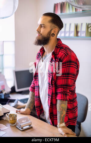 Thoughtful owner standing at checkout counter in candy store Stock Photo