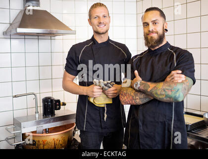 Portrait of smiling male workers standing in candy store Stock Photo