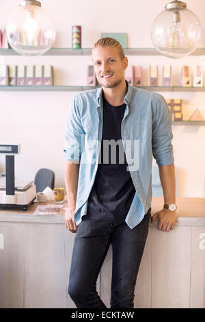 Portrait of smiling male owner standing candy store Stock Photo