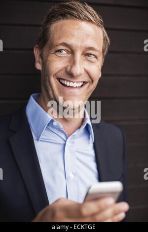 Happy businessman using smart phone Stock Photo