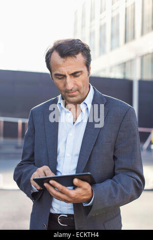 Businessman using digital tablet outdoors Stock Photo