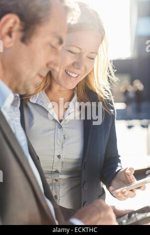 Businesspeople using mobile phones outdoors Stock Photo