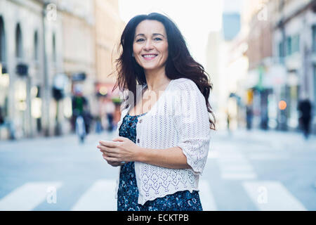 Side view of smiling mature woman standing on street Stock Photo