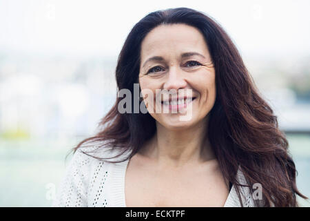 Portrait of smiling mature woman standing outdoors Stock Photo