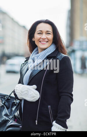 Portrait of smiling woman on standing on street in city Stock Photo