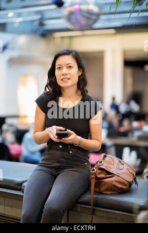 Portrait of woman using mobile phone in restaurant Stock Photo