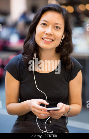 Portrait of woman using mobile phone in restaurant Stock Photo