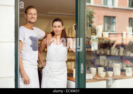 Portrait of smiling workers standing on doorway of crockery workshop Stock Photo