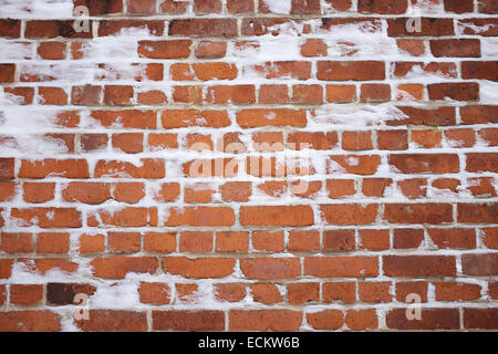 Rustic red brick background with fresh winter snow in the crevices Stock Photo