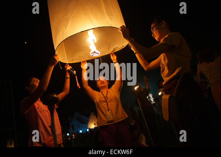 CHIANG MAI, THAILAND - OCTOBER 25, 2014: Group of young Thai people launch a sky lantern on the night of the Yee Peng festival. Stock Photo