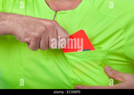 Referee whips out a red card from his pocket. Stock Photo